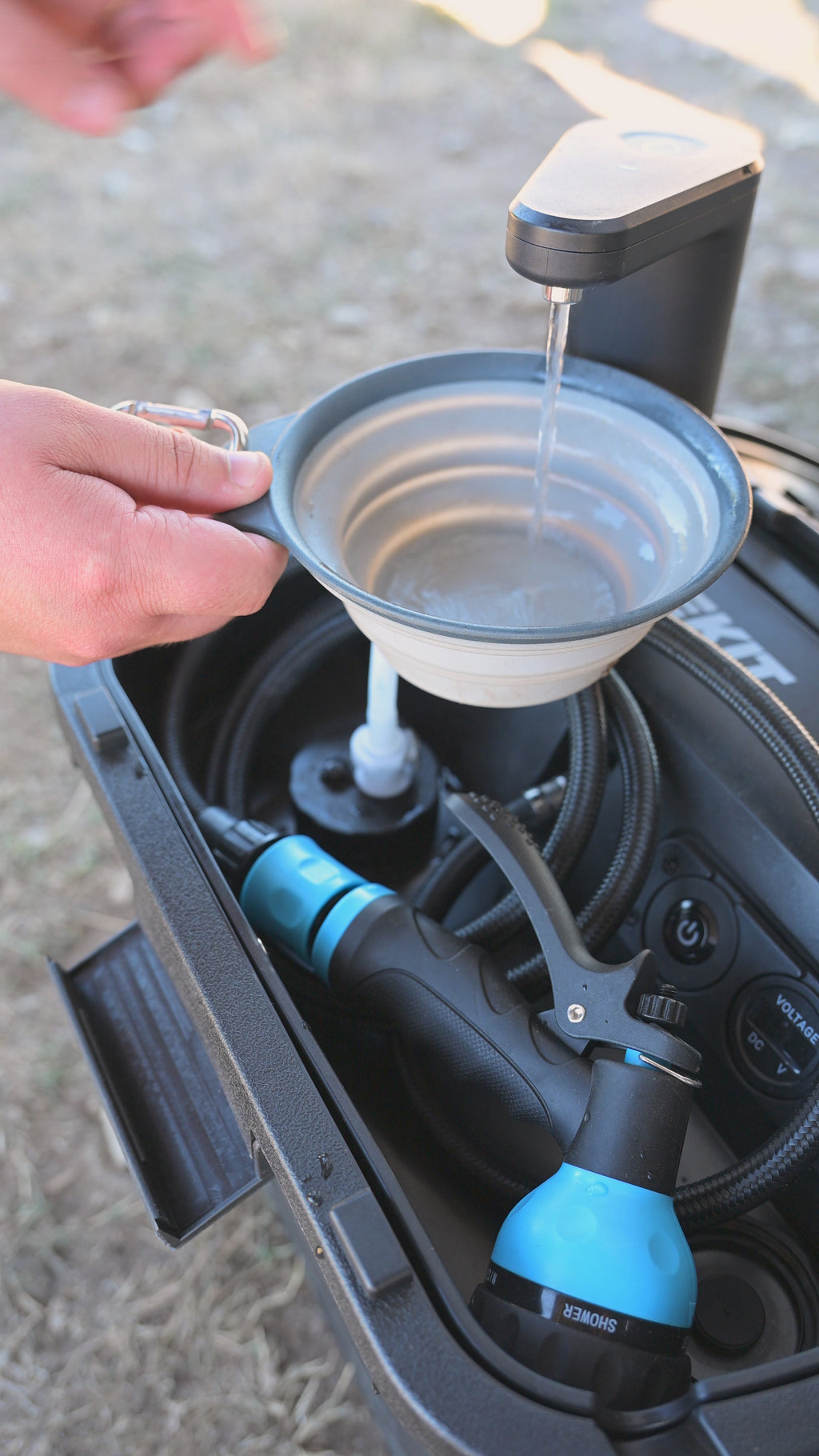 Close-up of the Dometic GO faucet dispensing water into a bowl while the RinseKit hose and sprayer stay stowed